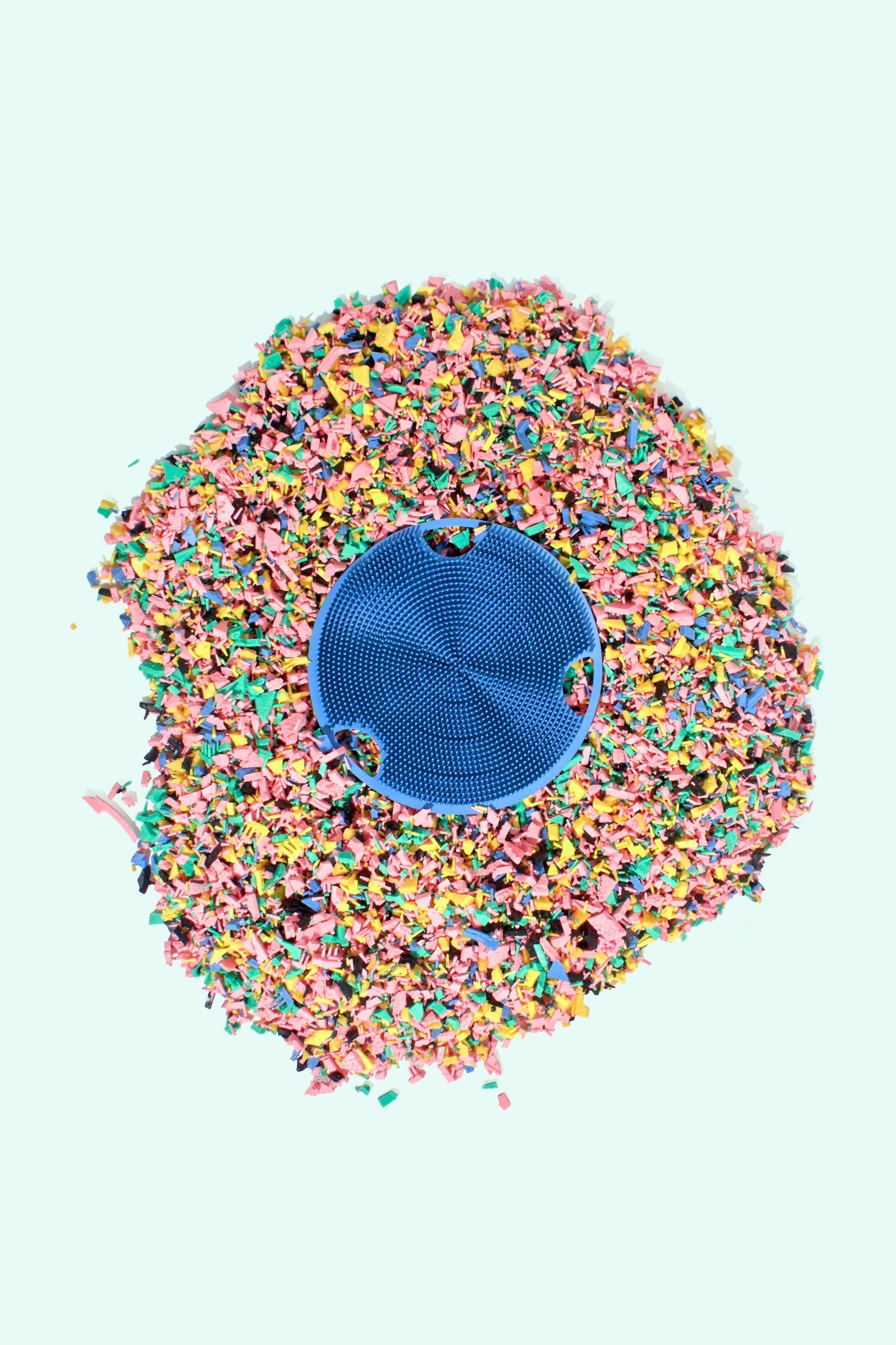 Boie's Body Scrubber laying on top of pieces of recycled Body Scrubber material